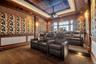Home theater featuring crown molding, a decorative wall, a raised ceiling, carpet flooring, and recessed lighting