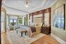 Bedroom featuring crown molding, a raised ceiling, light wood-style flooring, french doors, and recessed lighting