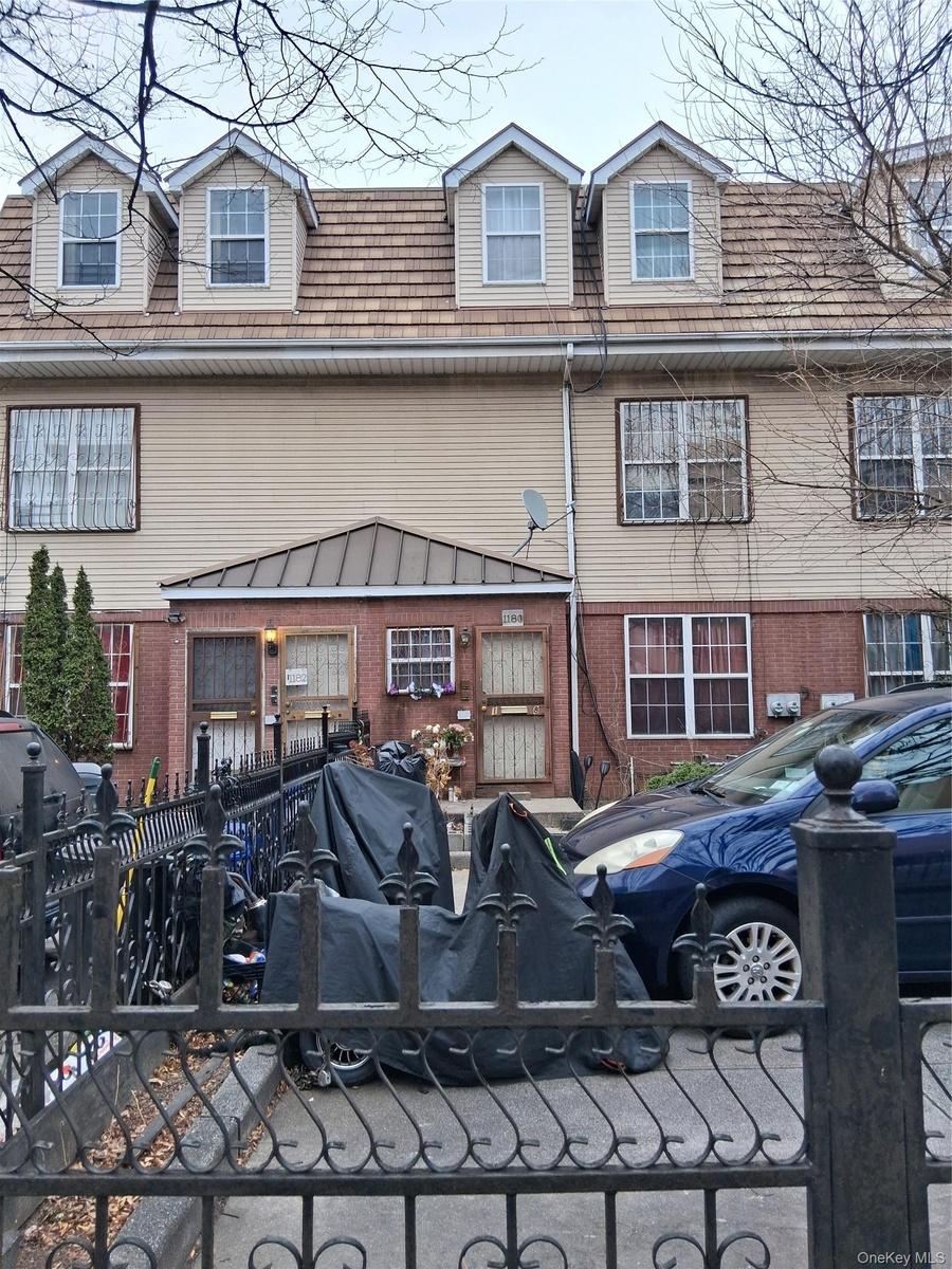 View of front facade featuring brick siding and a fenced front yard