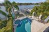 A serene private balcony offering panoramic views of the pool, water, and deep-water dock.