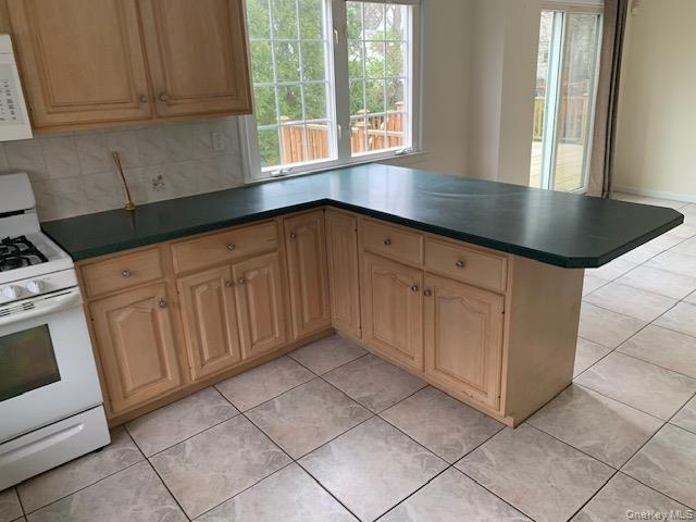 View on other side of counter of dining area and sliders out to deck