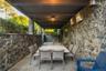 Covered outdoor patio featuring stone walls, an overhead ceiling fan, recessed lighting, and a stone slab floor