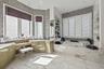 Spacious bathroom featuring large format marble flooring, a built-in soaking tub with marble surround, and an integrated vanity area with dual sinks a