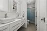 Contemporary bathroom featuring a double vanity with vessel sinks, white cabinetry, and brushed nickel hardware