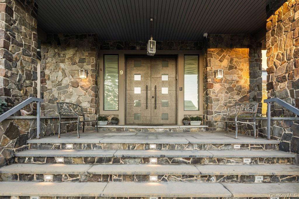 Stone facade entry featuring double doors with square glass inserts