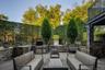 Outdoor patio featuring an integrated built-in grill station, stone-clad retaining walls, and a bluestone patio surface