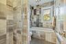 Contemporary bathroom featuring a glass-enclosed shower, a deep soaking tub, and a window for natural light