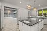 Spacious kitchen featuring an expansive center island with an integrated sink, white cabinetry, a mosaic tile backsplash, and recessed lighting