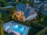 Expansive outdoor living space featuring a rectangular swimming pool, integrated spa, and paved sundeck