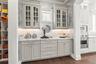 Butler's pantry with marble countertops, gorgeous designer wallpaper, custom lighting & ample storage connecting the kitchen to the large walk-in pant