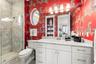 Private ensuite bath with legendary Scalamandre "Zebras" wallpaper traveling around the room and into the linen closet, modern marble shower, vanity a
