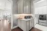 Additional view of the butler's pantry facing the kitchen and laundry room door, note custom millwork as well