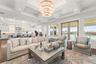 Spacious open-concept great room showcasing a custom surround sound home theatre, crystal chandelier, commissioned artwork, coffered tray ceilings, wa