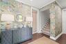 Entrance foyer with custom wallpaper and lighting, three story elevator, two accesses to garage and staircase leading to home's main living level