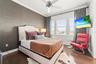 Bedroom 3 with beautiful water views, designer wallpaper, mounted television, and access to a Jack-and-Jill bath