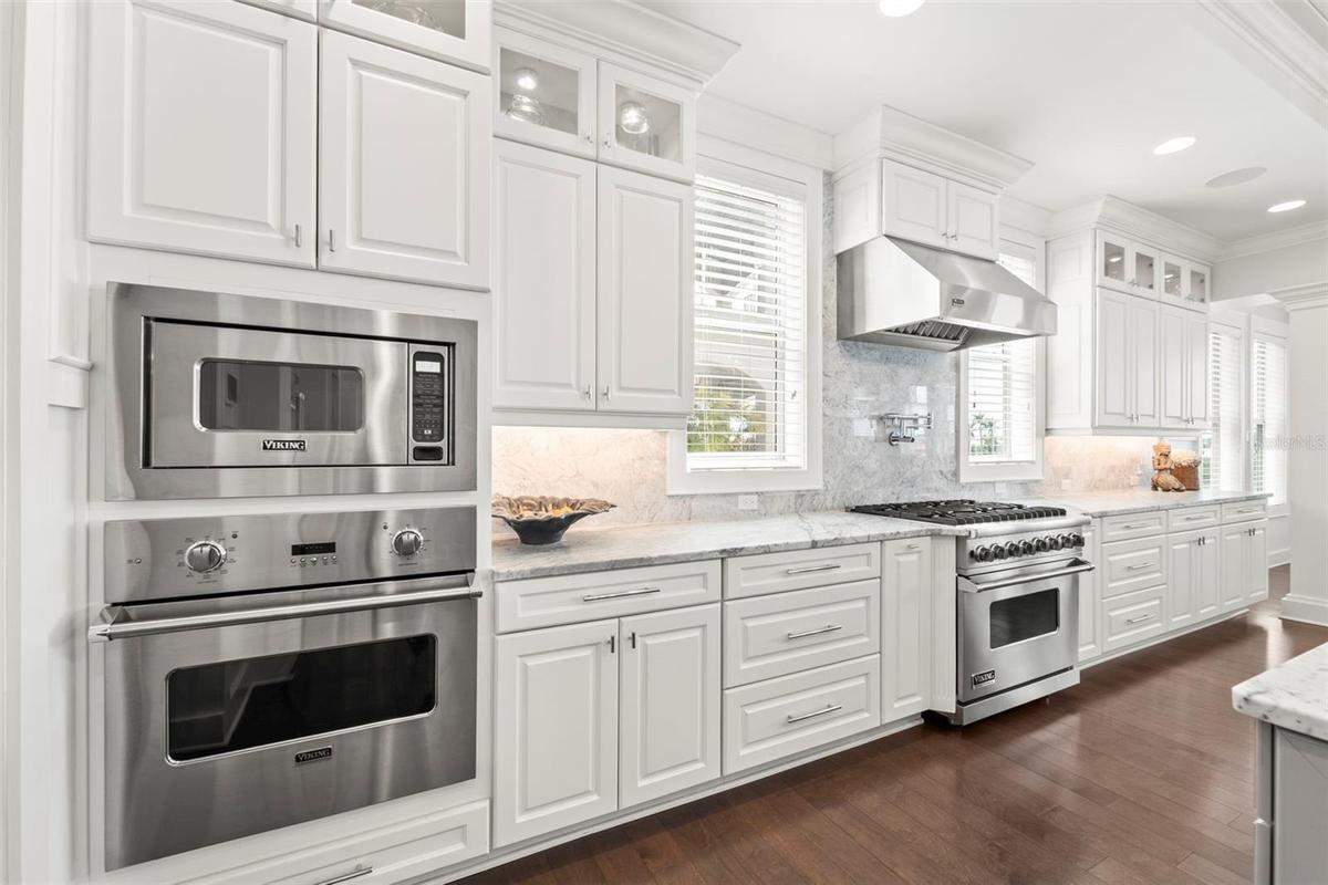 This kitchen is a chef's dream! Outfitted with premium gas-powered Viking appliances, including dual convection ovens, a professional six-burner cookt