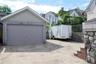 Detached garage with a paneled door, stucco finish, and an asphalt shingle roof.  Electric Car Charging Station in Garage