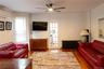 Open-concept living space with wood-finish flooring, a ceiling fan, and white walls