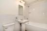 Hallway bath, newly renovated with modern flooring and subway tile.