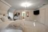 Carpeted bedroom featuring ensuite bath and crown molding