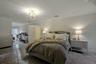 Bedroom with crown molding, a notable chandelier, and dark colored carpet