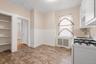 Compact kitchen with patterned floor tiles, white wainscoting, and built-in shelving