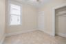 Room featuring a patterned tile floor, neutral wall paint, and white trim