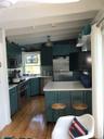 Kitchen featuring appliances with stainless steel finishes, hardwood / wood-style floors, light countertops, a peninsula, and blue cabinetry