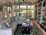 Living area with wood finished floors, a baseboard radiator, and beam ceiling