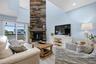 Main floor Living Room with vaulted ceiling and impressive fireplace with wood accent wall.