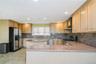 Kitchen featuring light-toned cabinetry, stainless steel appliances, and stone countertops