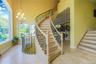 Grand curved staircase featuring wood-finish treads and an ornate metal railing