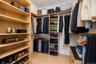 Custom closet system featuring light wood-finish shelving and extensive hanging storage