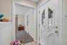 Foyer entrance featuring light carpet, plenty of natural light, a baseboard heating unit, and light tile patterned floors