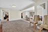 Living area featuring light tile patterned floors, light carpet, and a baseboard heating unit
