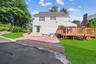 Back of property with a yard, a chimney, and a wooden deck