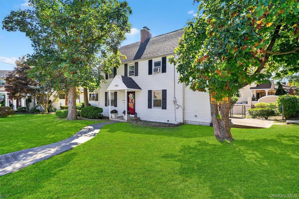 Colonial-style house with a chimney and roof with shingles