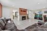 Living area featuring light tile patterned floors, recessed lighting, and a fireplace
