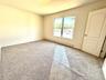 Spacious room featuring neutral carpeting and light-toned walls