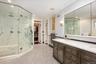 Bathroom featuring a marble finish shower, crown molding, recessed lighting, vanity, and a walk in closet