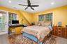 Bedroom featuring multiple windows, wood finish floors, a desk, and recessed lighting