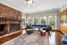 Living room featuring hardwood / wood-style flooring, crown molding, a brick fireplace, recessed lighting, and a chandelier