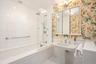 Bathroom with tiled shower / bath and wallpapered walls