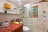 Bathroom featuring plenty of natural light, a stall shower, tile walls, and vanity