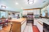 Kitchen featuring white cabinetry, light wood-finish countertops, stainless steel appliances, and a checkerboard tile backsplash