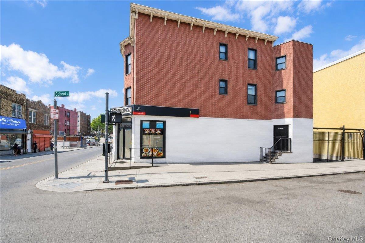 Commercial building featuring a brick upper facade and a white lower facade
