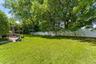 Flat, fenced yard with mature landscaping for privacy