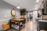 Galley kitchen with dark wood-finish cabinetry, stainless steel appliances, and wood-finish flooring