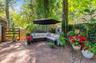 Brick paver patio featuring a slatted wood fence and a shingled shed
