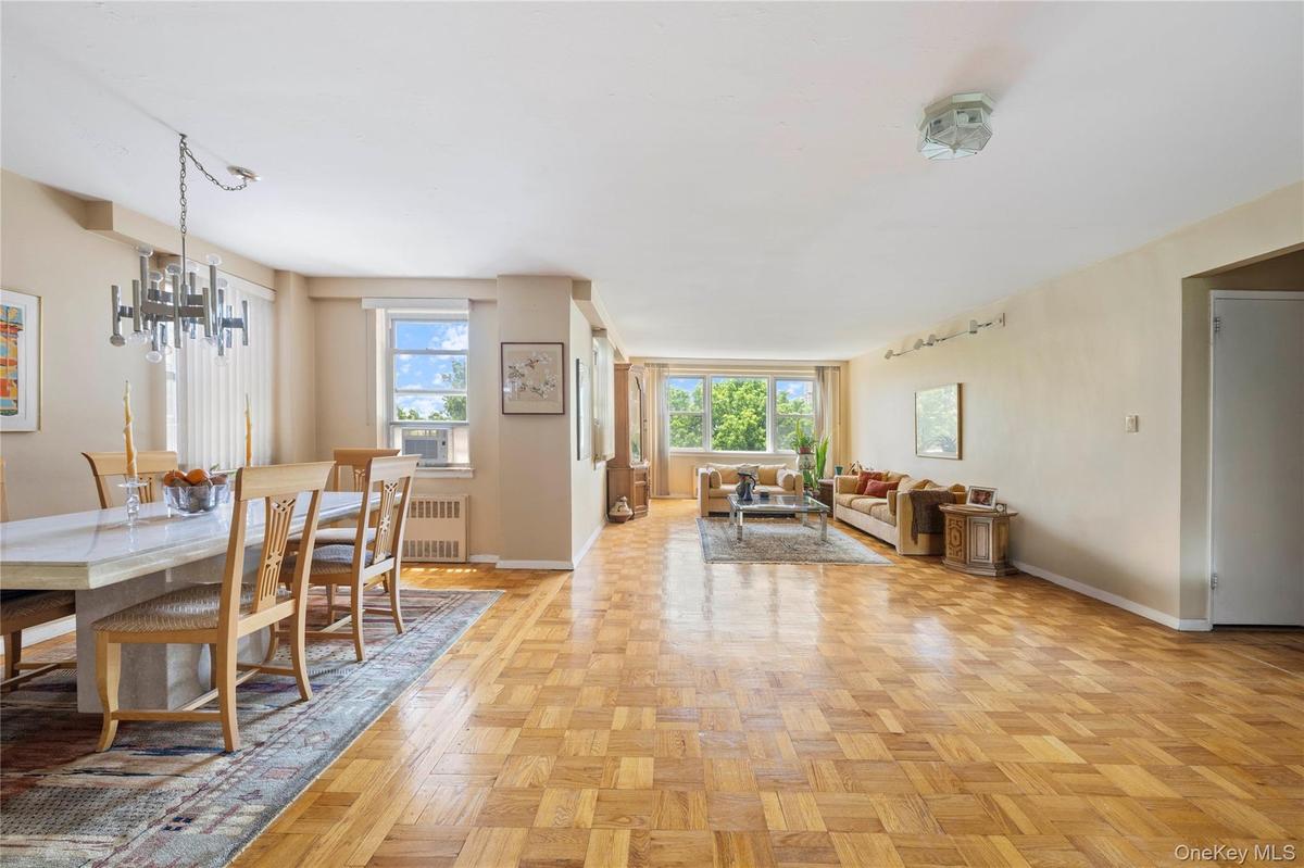 Spacious open-concept living and dining areas featuring parquet wood flooring throughout